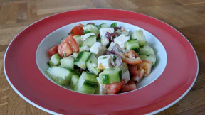 Ein Salat aus Tomaten-, Gurken- und Feta-Würfeln mit Zwiebeln