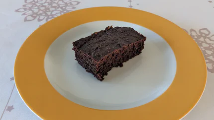 Ein rechteckiges Stück Brownies. Es ist ziemlich fluffig.