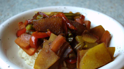 Grobe Stücke Rübe, Bohnen, Paprika und anderem Gemüse auf Reis mit Sojasauce.