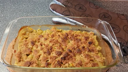 Eine Auflaufforom mit einer süß-sauren Masse aus Rhabarber bestreut mit knusprigen Streuseln.