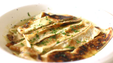Gleichmäßig geschnittene Streifen Pfannkuchen schwinmmen in einer Brühe.