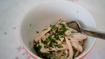 Ein Salat aus Lyonerstreifen, Mayonnaise, Gurken und Schnittlauch.