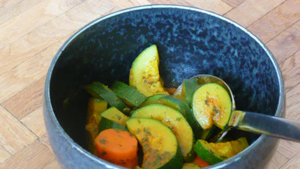 Eine Schale mit halben Zucchinischeiben und Rübe, Kräutern und Gorgonzola.