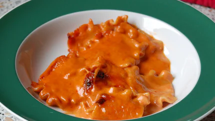 Flache Nudeln in einer Tomaten-Sahnesauce mit einzelnen braunen Stellen.