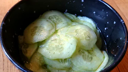 Eine Schale mit feinen Gurkenscheiben in einem Dressing aus Essig, Öl, Salz und Dill.