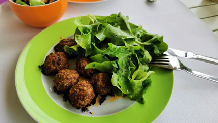 Sechs braun gebratene Hackfleischküchle mit Blattsalat.