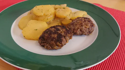 Zwei braun gebratene Hackfleischküchle mit Kartoffelsalat.