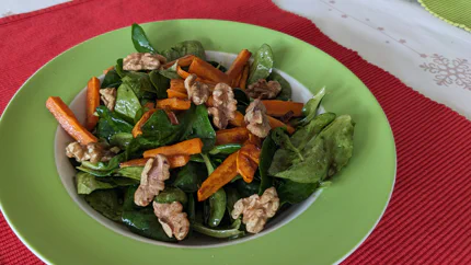 Ackersalat mit gerösteten Walnüssen und Rüble in einem tiefen Teller.