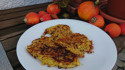 Dunkelbraun gebratene Kartoffelpuffer aus langen Kartoffelraspeln.