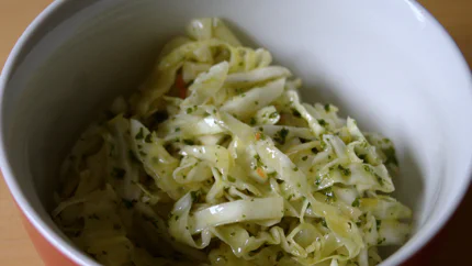 Eine Schale Krautsalat mit Petersile und Dressing.
