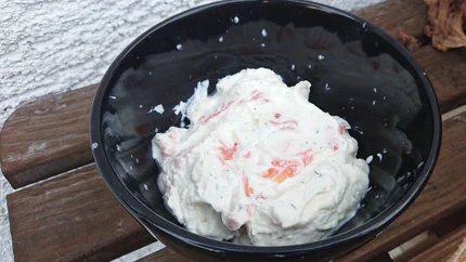 Eine Schale mit einer dickflüssigen Creme aus Frischkäse und Schmand mit Räucherlachs.