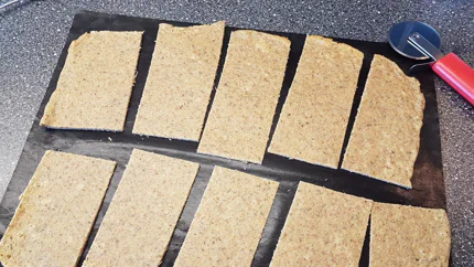 Rohe, geschnittene Lasagneblätter liegen auf einem Backpapier.