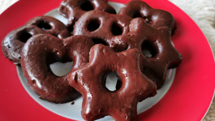 Sieben mit Schokolade umgebenen Lebkuchen auf einem Tisch mit Weihnachtsdecke.