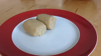Zwei zylinderförmige Stücke Marzipan auf einem Teller.