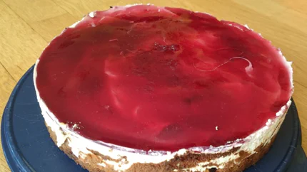 Ein Kuchen aus zwei Scheiben Biskuitteig, steifer Sahne und einem Guss aus Kirschsaft.