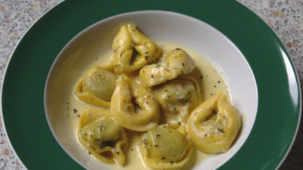 Eine Portion Tortellini in einer flüssigen Sahnesauce mit Brühe und Pfeffer.