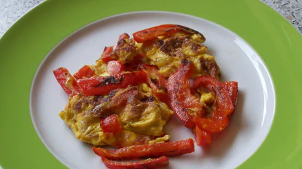 Eine Portion verquirlte Eier, die mit Paprikastreifen angebraten wurden.