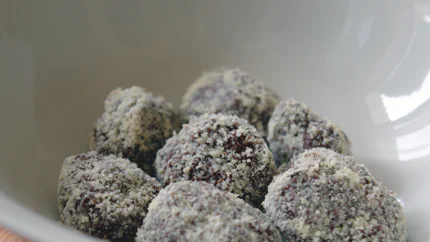 Sieben mit Kokosraspel bedeckten Kugeln aus Schokolade und Whisky liegen in einem Schälchen.