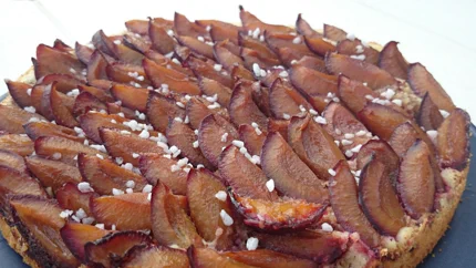 Ein runder Kuchen mit dickem Mürbteig ohne Rand, auf dem die Zwetschgen ziegelartig geschichtet und mit Hagelzucker bestreut sind.