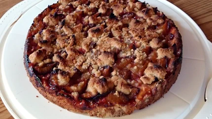 Ein runder Kuchen mit dickem Mürbteig, auf dem die Zwetschgen ziegelartig geschichtet und mit Sträusel bedeckt sind.